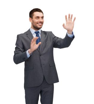 business, technology, communication concept - smiling businessman working with imaginary virtual screen