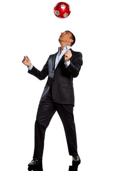 one  business man playing juggling soccer ball in studio isolated on white background