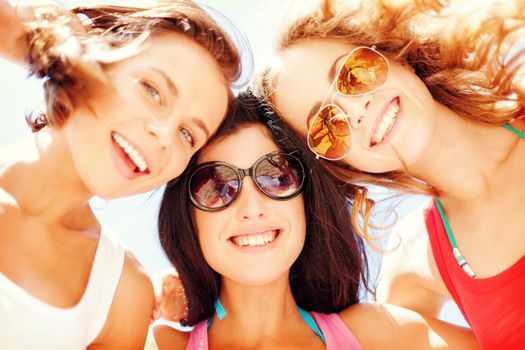 summer holidays and vacation - girls faces with shades looking down