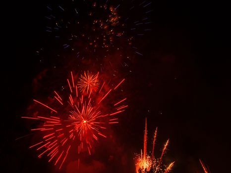 Red fireworks exploding in the black sky