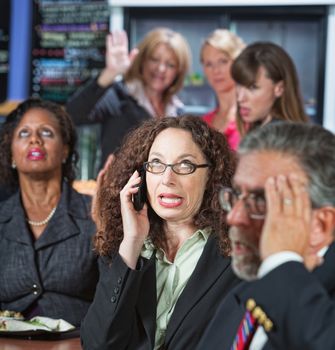 Loud woman on cell phone in cafeteria with coworkers