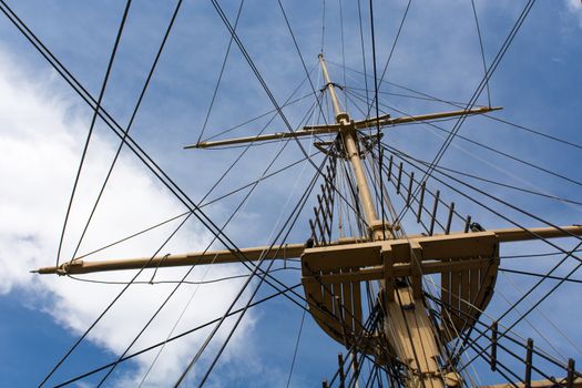 Mast and rigging of a big old sailing ship in front of a blue sky