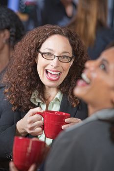 Pair of female friends laughing together in cafe