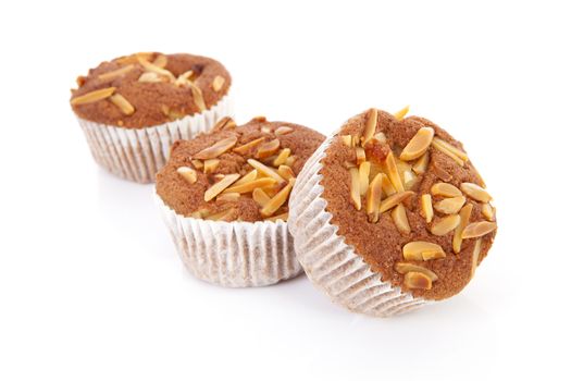 three biscuit cupcakes with nuts over white background