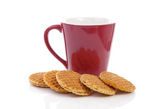 Pile of typical Dutch stroopwafels ( with syrup) near coffee cup over white background