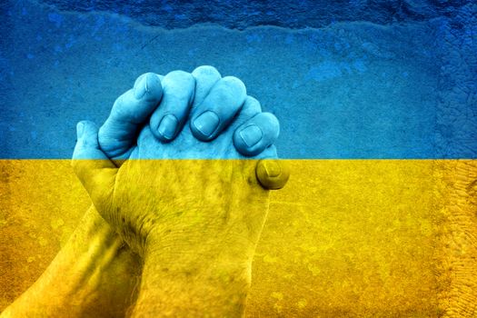 Mature Hands in Pray Gesture on the Dirty National flag of Ukraine