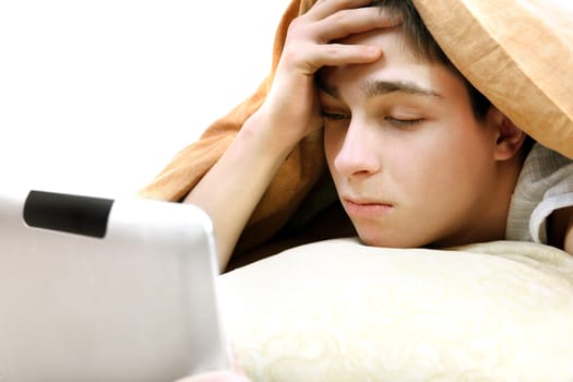 Serious Teenager with Tablet Computer under Blanket at the Home