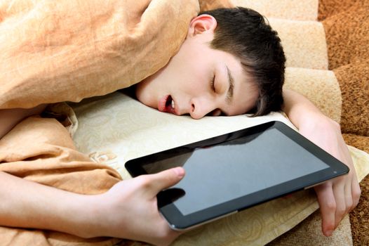 Tired Teenager sleeping on the Bed with Tablet Computer