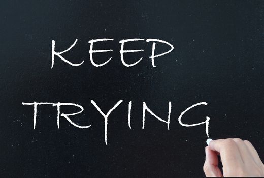 Keep trying hand written on a chalkboard