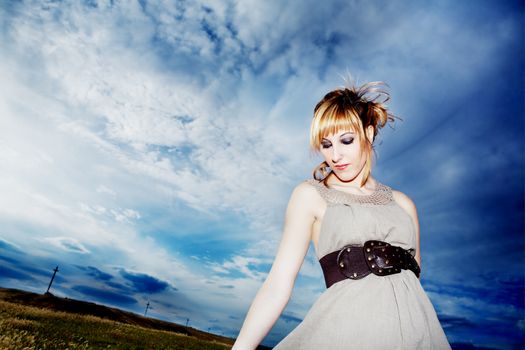 Fashion. Portrait girl outdoors wearing dress and belt with blue sky