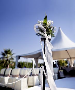 Beautiful ceremony venue with flowers and blue sky.