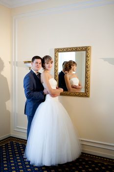 bride and groom by the mirrir