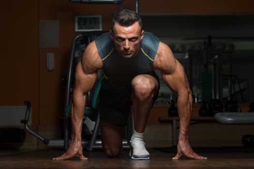 Strong Muscular Men Kneeling On The Floor - Almost Like Sprinter Starting Position