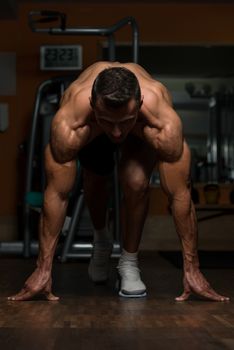 Strong Muscular Men Kneeling On The Floor - Almost Like Sprinter Starting Position