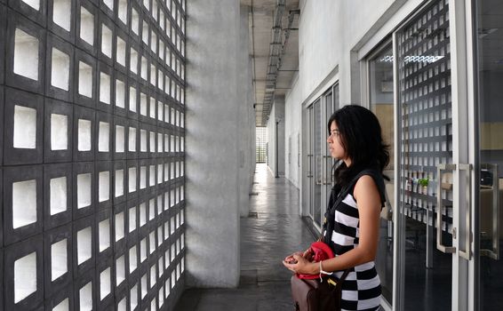 Beautiful hispanic woman with a sad expression on a dramatic background 