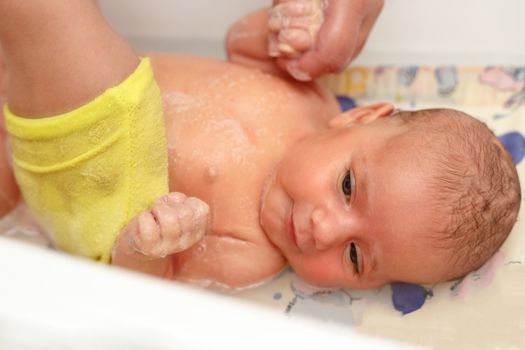 take a bath at home for a young adorable baby girl, one moth old