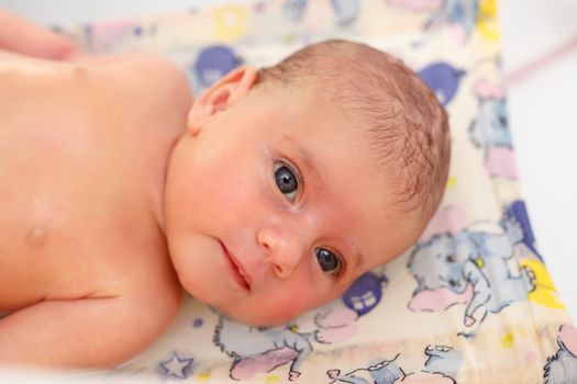 take a bath at home for a young adorable baby girl, one moth old