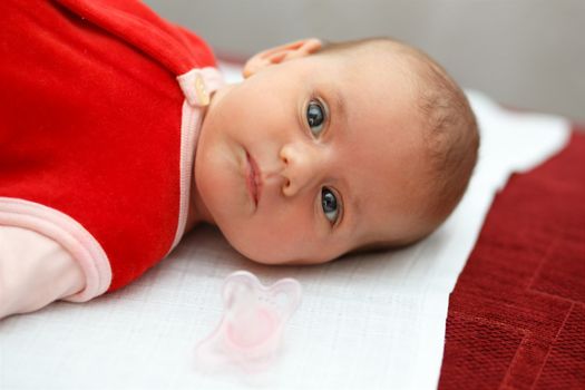 newborn, lying one month old baby in red dress