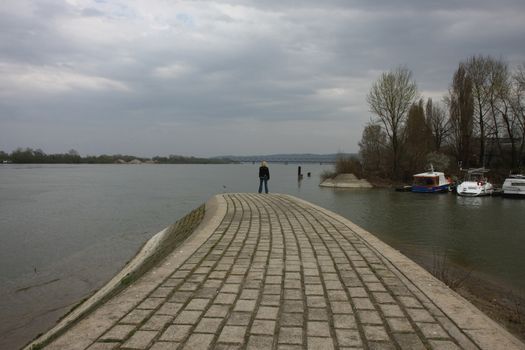 Lady standing on the end of river quay