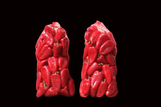 Red paprika in two sacks isolated on black