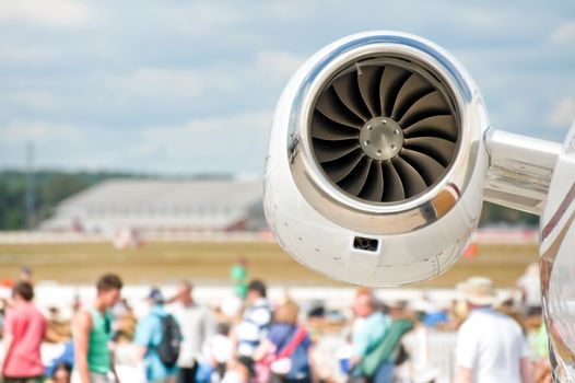 aircraft jet engine closeup and airshow crowd in the background
