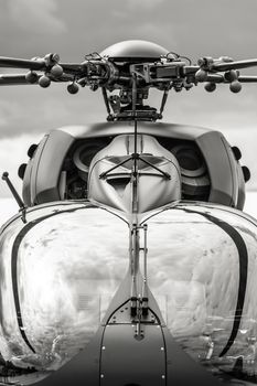 black and white closeup of military combat helicopter cockpit and rotor blades