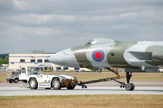 Farnborough, UK - July 24, 2010: Vulcan bomber XH558 being towed by an airfield tug truck at the Farnborough Airshow, UK