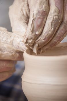 Hands of a potter, creating an earthen jar on the circle