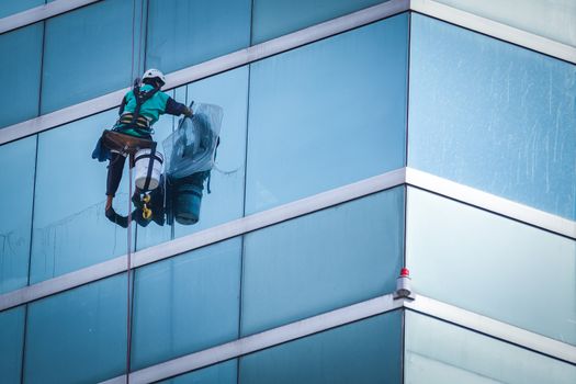 group of workers cleaning windows service on high rise building