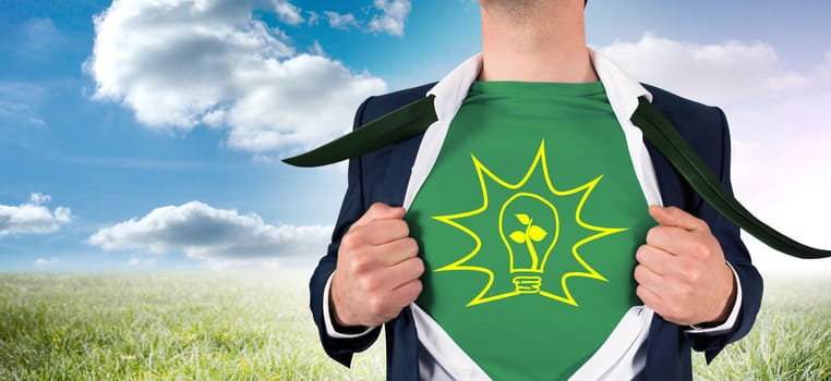 Businessman opening shirt in superhero style against sunny landscape