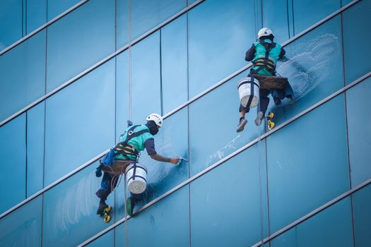 group of workers cleaning windows service on high rise building