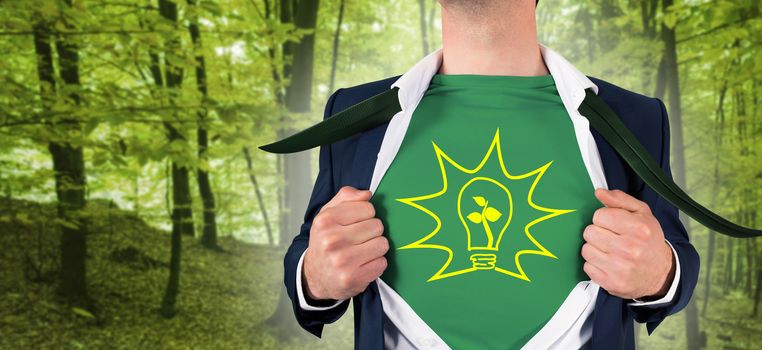 Businessman opening shirt in superhero style against peaceful green forest