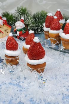 strawberries with whipped cream in the form of a Christmas hat on a muffin