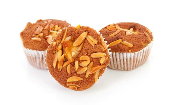 three biscuit cupcakes with nuts over white background