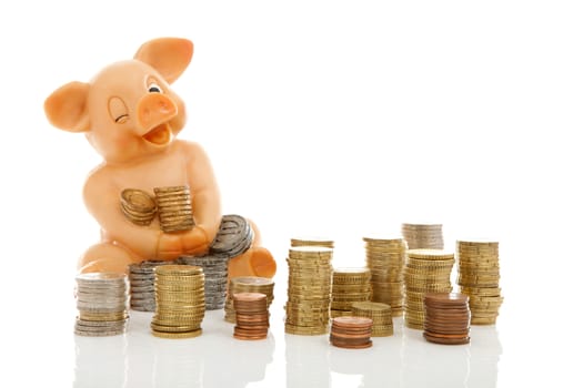 Funny piggy bank and piles of coins over white background