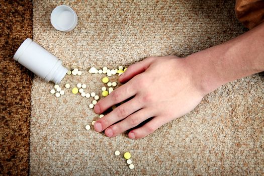 Hand near the scattered Pills close-up