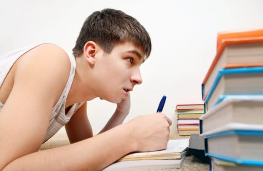 Side view of the Teenager doing Homework at the Home