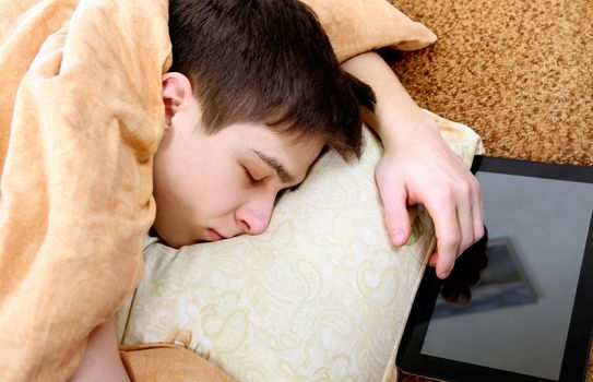 Tired Teenager sleeping on the Bed with Tablet Computer