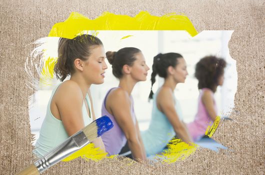 Composite image of yoga class in the gym against weathered surface with paintbrush