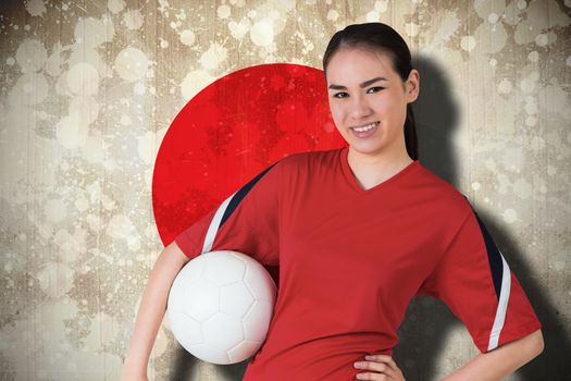 Composite image of smiling asian football fan looking at camera against japan flag