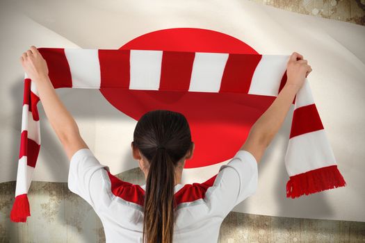 Composite image of football fan waving red and white scarf against japan flag