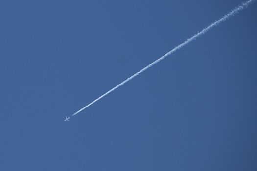 Vapour trail from a plane crosses across a perfect blue sky.