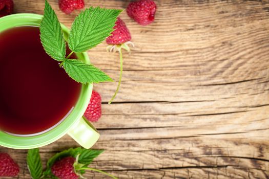 Raspberry tea with berry fruit on wooden table background. Copy space. Top view