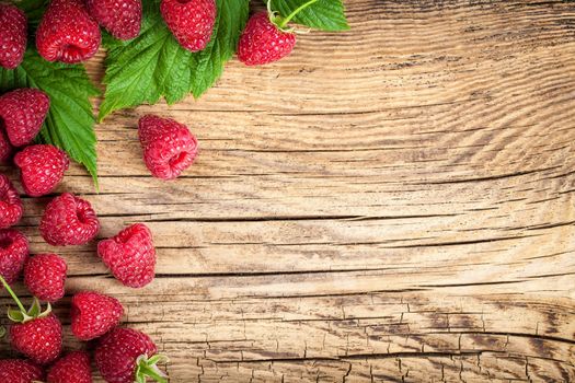 Raspberries on wooden table background. Copy space. Top view