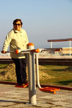 old woman doing sport in morning with tools