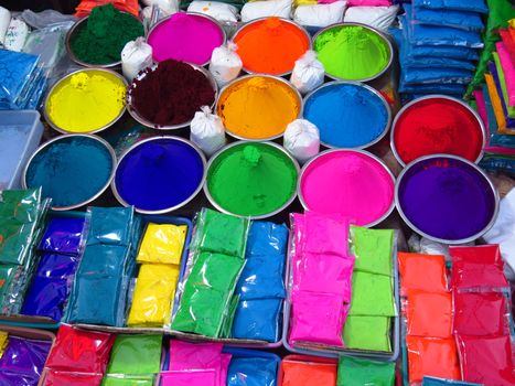 Different colors in bowls and packets for sale on the occassion of Holi Festival in India