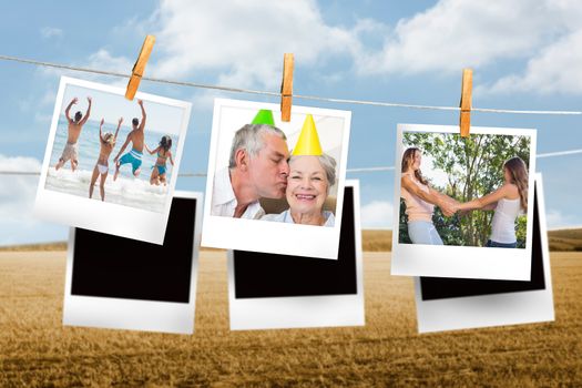 Composite image of instant photos hanging on a line against field and blue sky