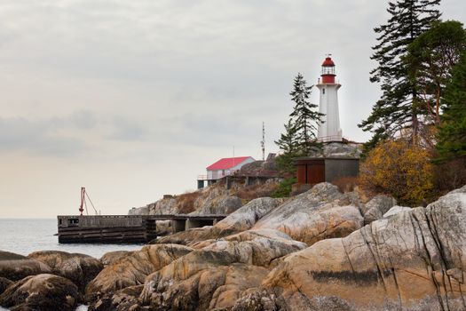 Coastal granite rock cliff with lighthouse building and communications antennas on British Columbia West Coast north of Vancouver, Canada