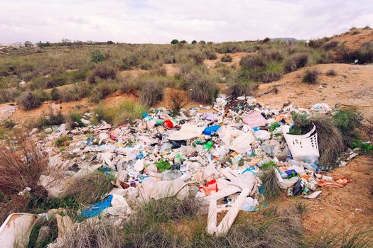 Pile of rubbish illegally dumped in natural landscape polluting nature environment