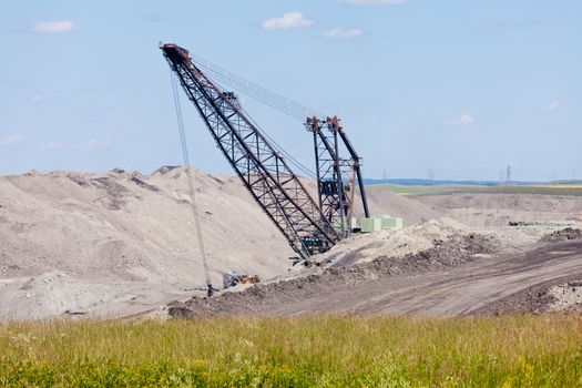 Coal mine industrial excavator machinery equipment among moon-like tailings landscape in Alberta, Canada